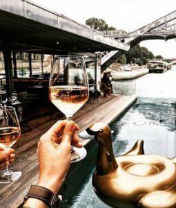 Holding wine in glass looking over the Seine