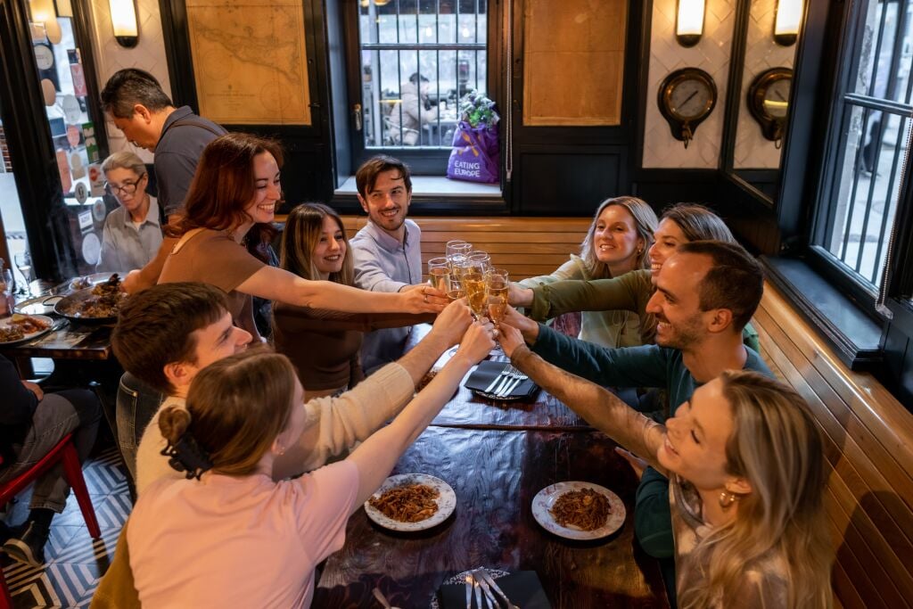 Guests cheering at the restaurant table with the guide