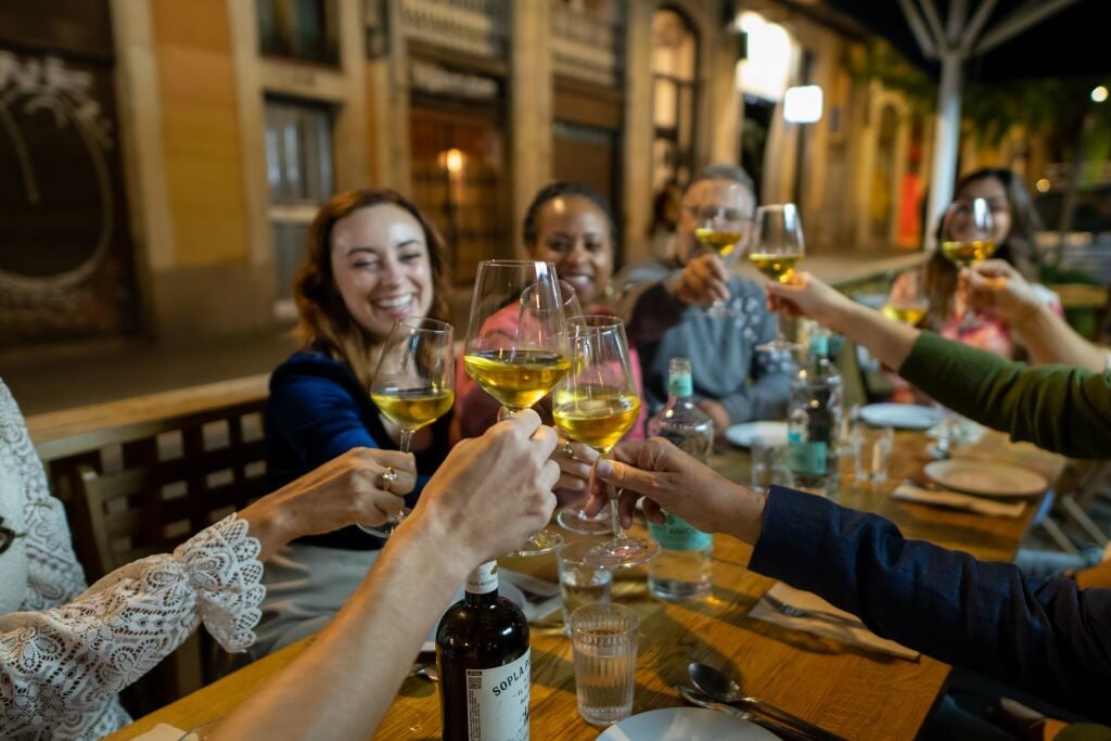 A Barcelona food tour group toast glasses of wine