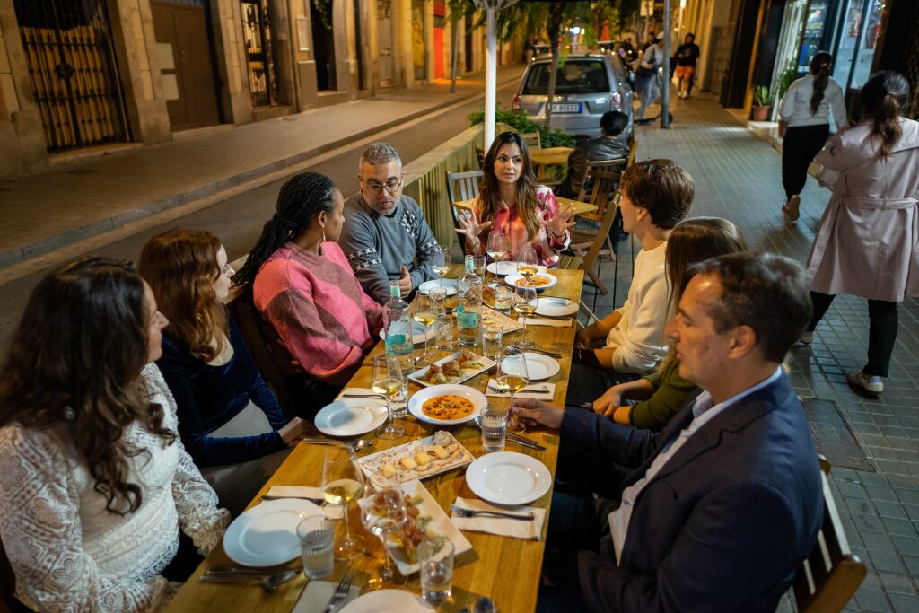 A Barcelona food tour group listen to their guide